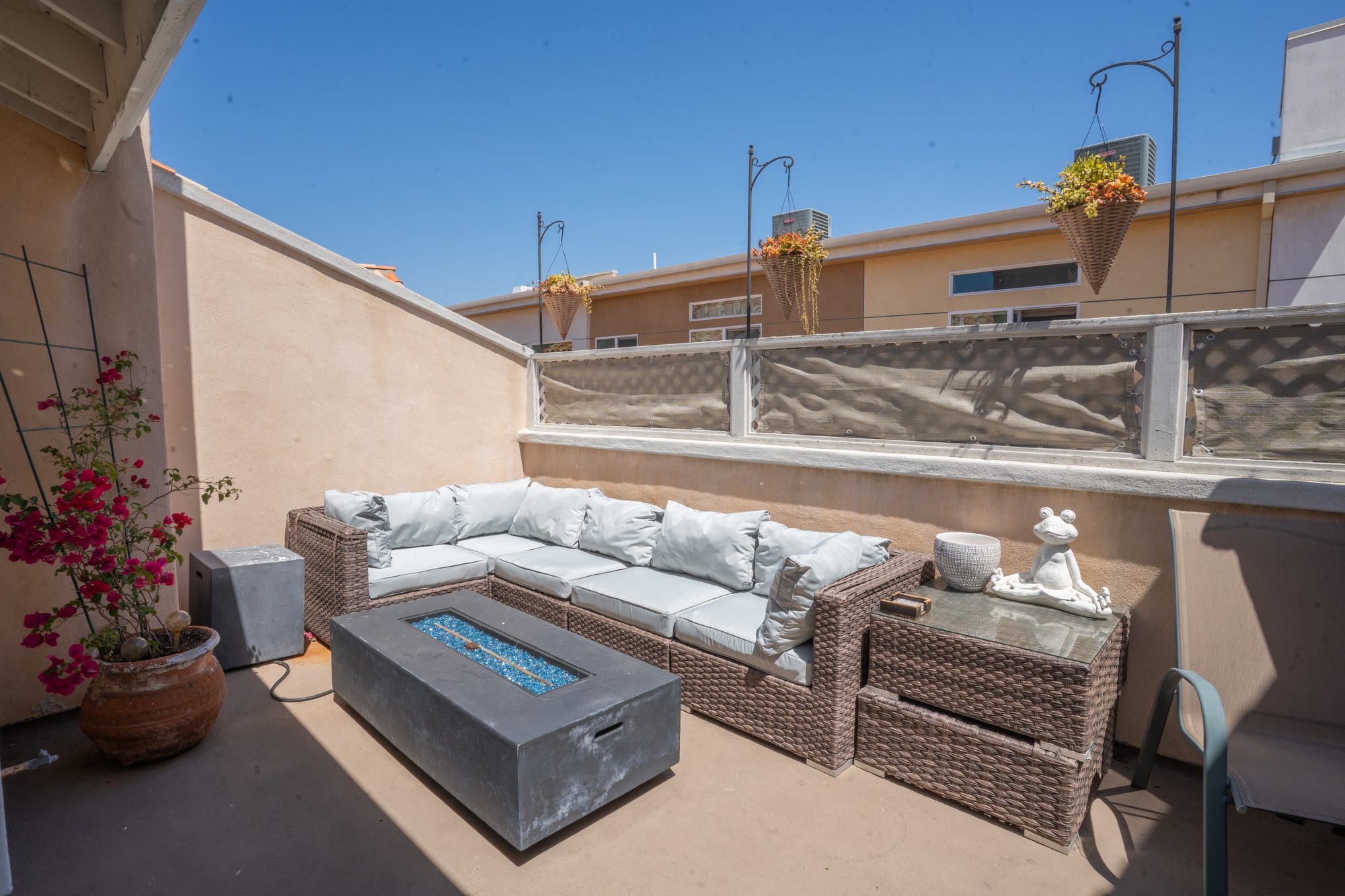 Private balcony with fire pit, sectional, and bougainvillea