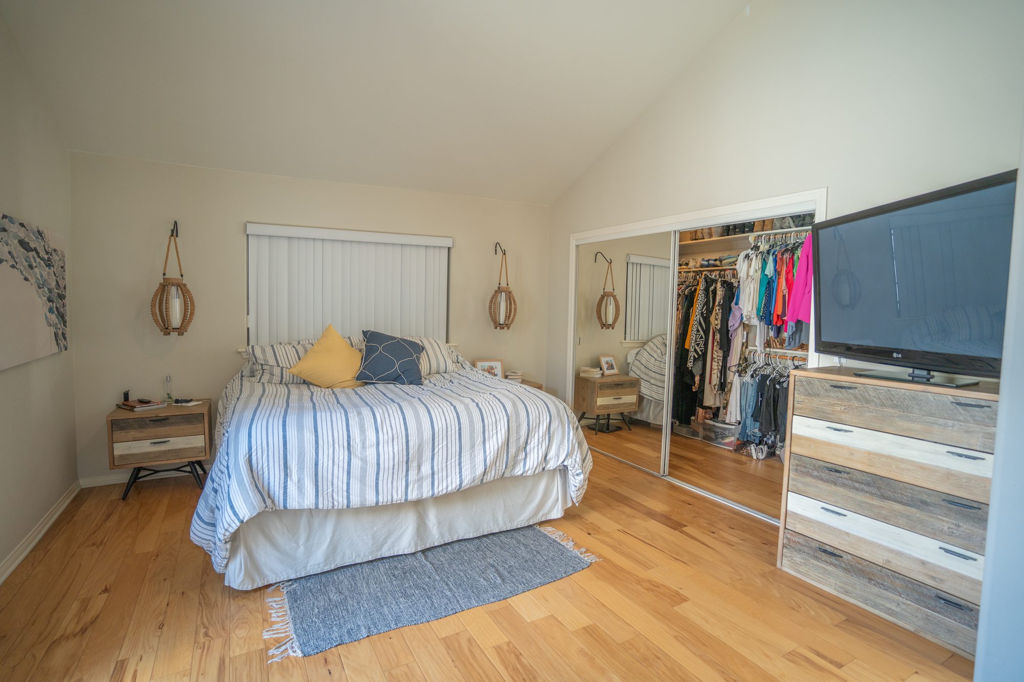 Primary bedroom showing king bed and walk-in closet with mirrored doors