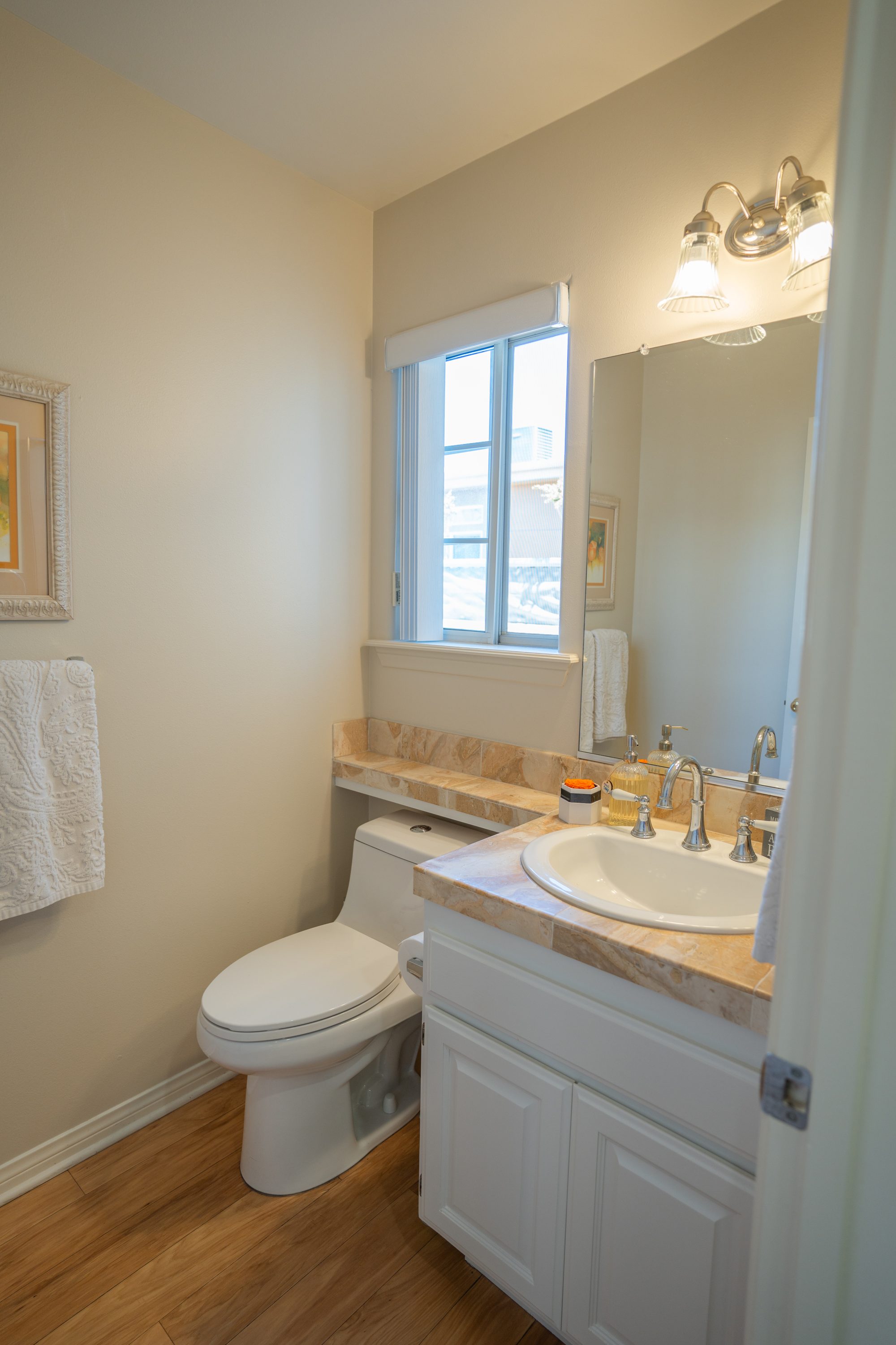 Downstairs full bathroom with white tile and beach decor